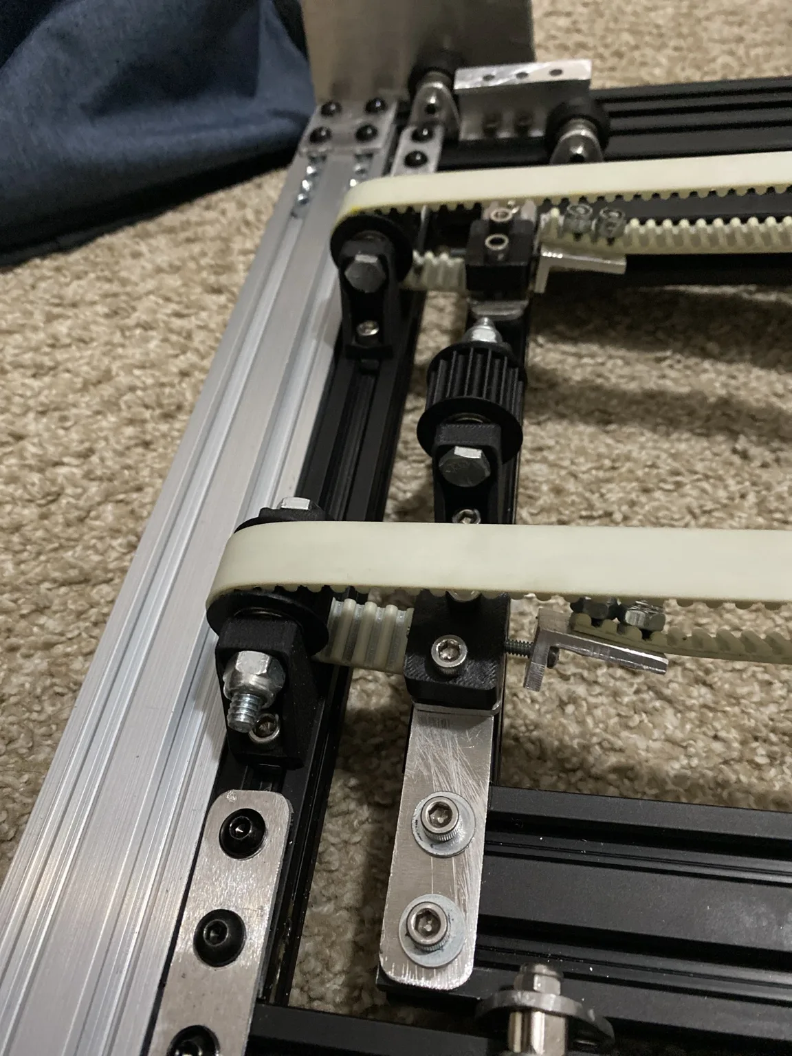 Close-up of the elevator belt tensioner, drive pulleys, and toothed belts on the assembled mechanism